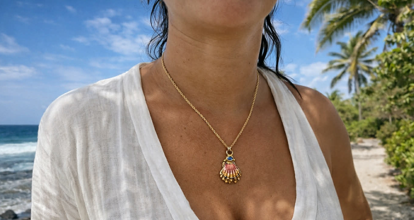 Person wearing a necklace with a shell pendant on a beach
